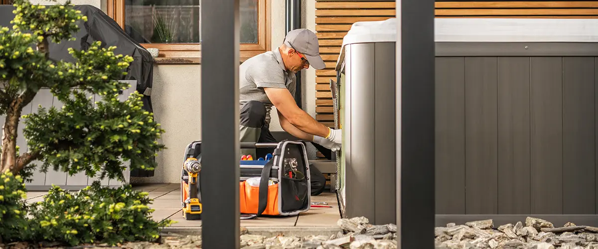 Electrician setting up outdoor hot tub wiring, with professional tools on the patio