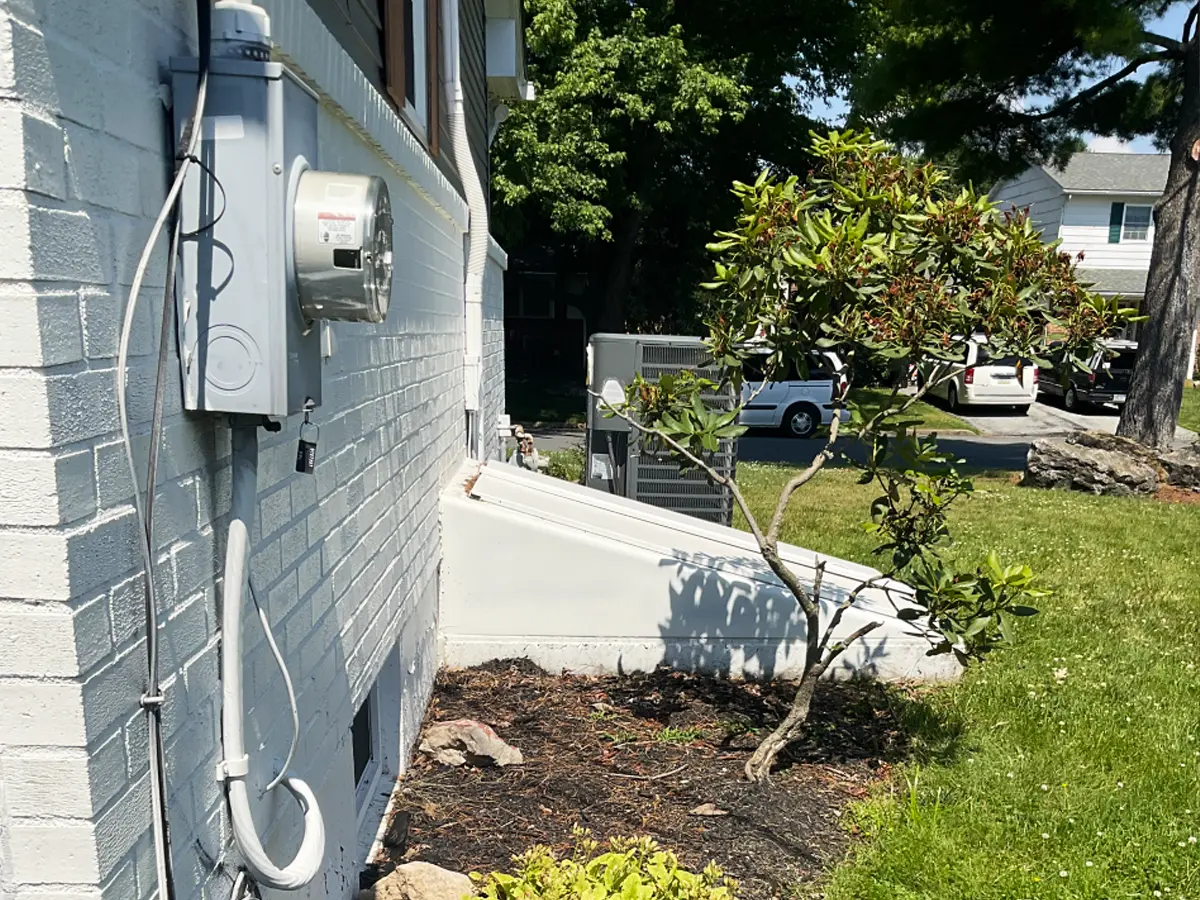 Exterior view of utility meter and generator transfer switch for home backup power system