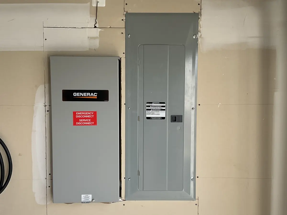 Generac and Ehrlich branded emergency transfer switches installed indoors for backup power solutions