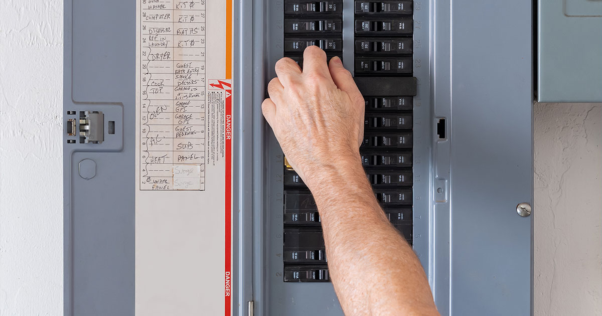 Hand adjusting circuit breaker in an electrical panel for home electricity management.