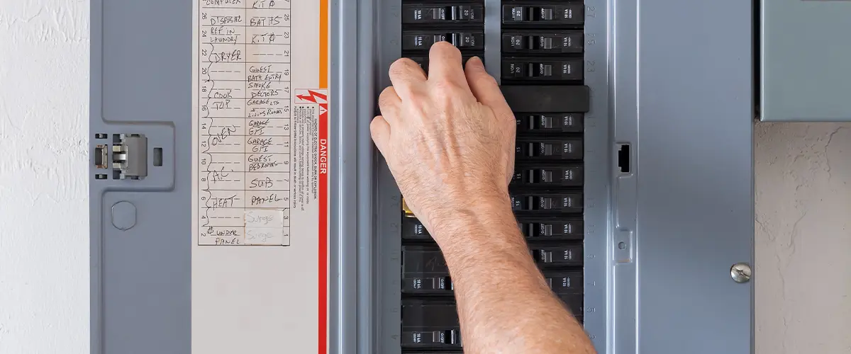 Hand adjusting circuit breaker in an electrical panel for home electricity management.