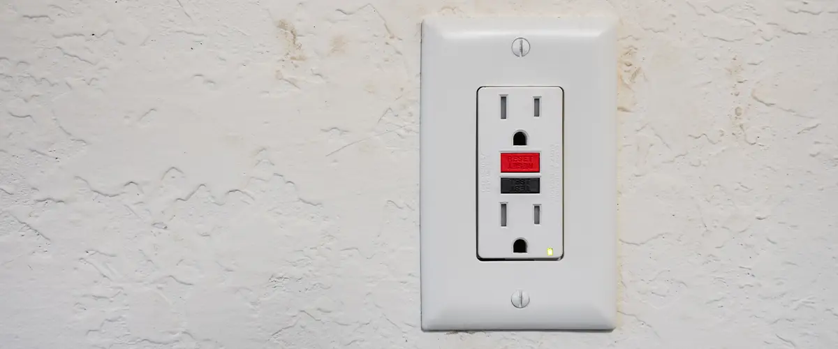 Installed GFCI outlet on a textured wall for safety in residential settings.