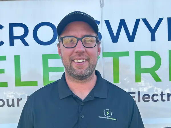 Crosswyre Electric owner standing in front of company van with logo, showcasing local electrical services.